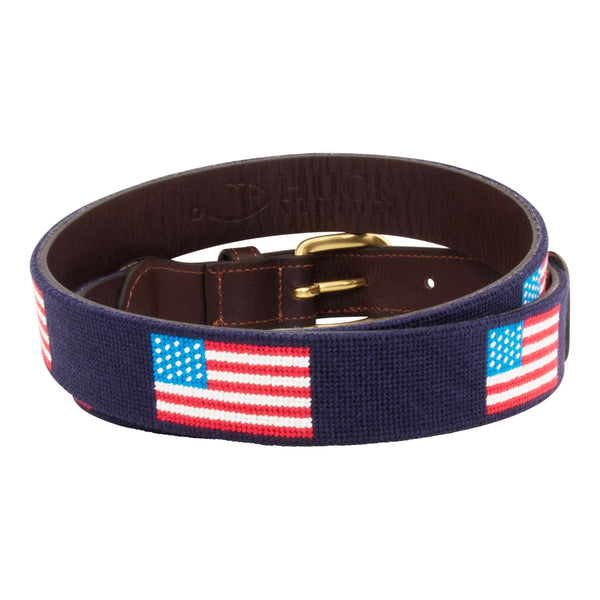 Back View of American Flag Needlepoint Belt with navy blue background and repeating pattern of evenly spaced american flags. Belt has a brass buckle and full grain leather backing and strap.