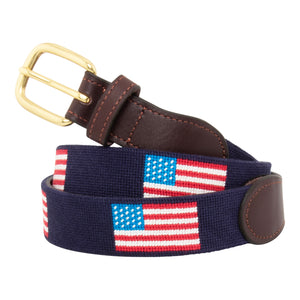 American Flag Needlepoint Belt with navy blue background and repeating pattern of evenly spaced american flags. Belt has a brass buckle and full grain leather backing and strap.