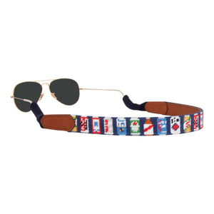 Beer themed needlepoint sunglass strap showing popular beer cans against a navy blue background with sturdy cotton covered silicone ear connectors and a soft leather backing