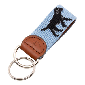 Hand-stitched black Labrador needlepoint keychain showing a black lab on both sides against a light blue background and leather backing.  Stainless steel D-ring and keyring.
