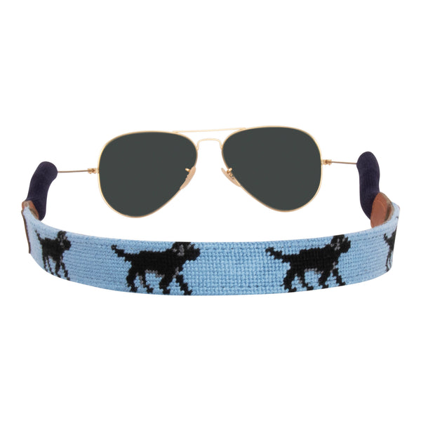 Back view black Labrador themed needlepoint sunglass strap showing a black lab design against a light blue background with sturdy cotton covered silicone ear connectors and a soft leather backing