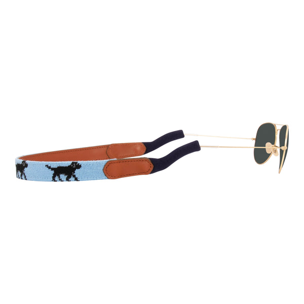 Side view black Labrador themed needlepoint sunglass strap showing a black lab design against a light blue background with sturdy cotton covered silicone ear connectors and a soft leather backing