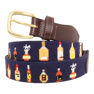 Bourbon Bottle Needlepoint Belt with navy blue background showing a repeating pattern of popularbourbon bottles around the belt. Belt has a brass buckle and full grain leather backing and strap.