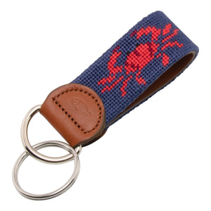 Hand-stitched crab needlepoint keychain showing a red crab on both sides against a navy blue background and leather backing.  Stainless steel D-ring and keyring.