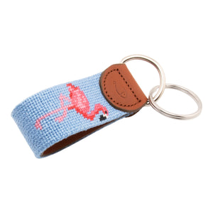 needlepoint keychain showing a pink flamingo on both sides against a light blue background, hand-stitched, leather backing, and stainless steel hardware