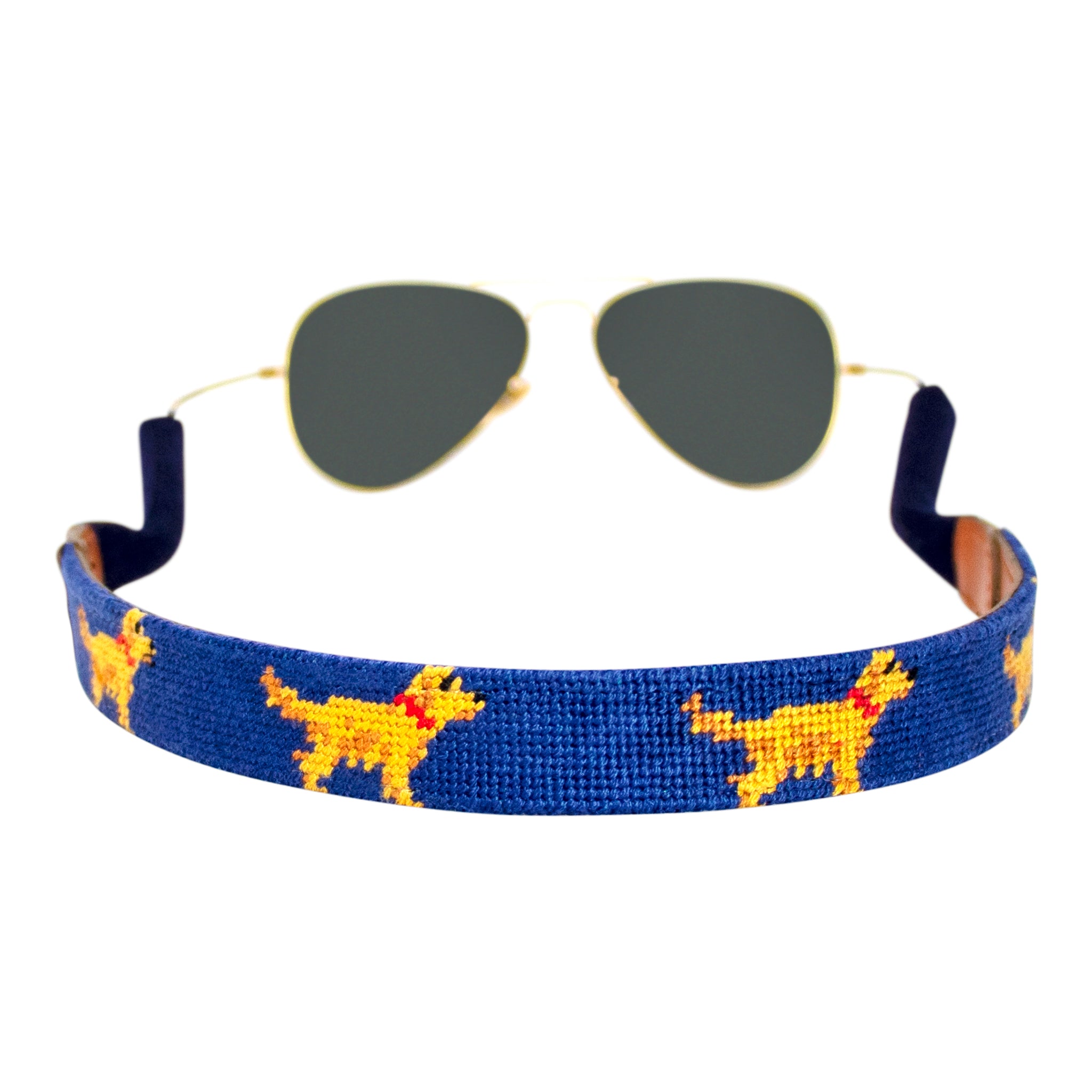 Golden retriever themed needlepoint sunglass strap showing a golden retriever design against a navy blue background with sturdy cotton covered silicone ear connectors and a soft leather backing