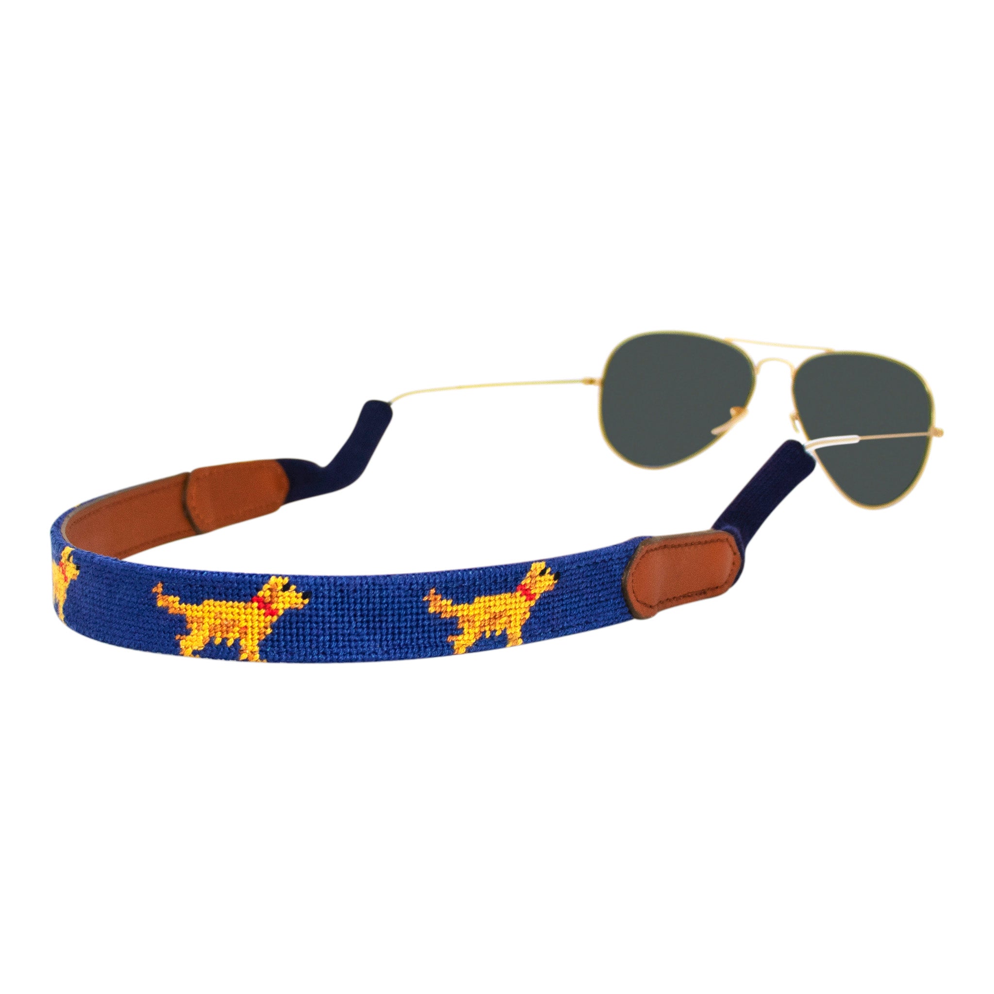 Golden retriever themed needlepoint sunglass strap showing a golden retriever design against a navy blue background with sturdy cotton covered silicone ear connectors and a soft leather backing