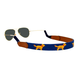 Golden retriever themed needlepoint sunglass strap showing a golden retriever design against a navy blue background with sturdy cotton covered silicone ear connectors and a soft leather backing