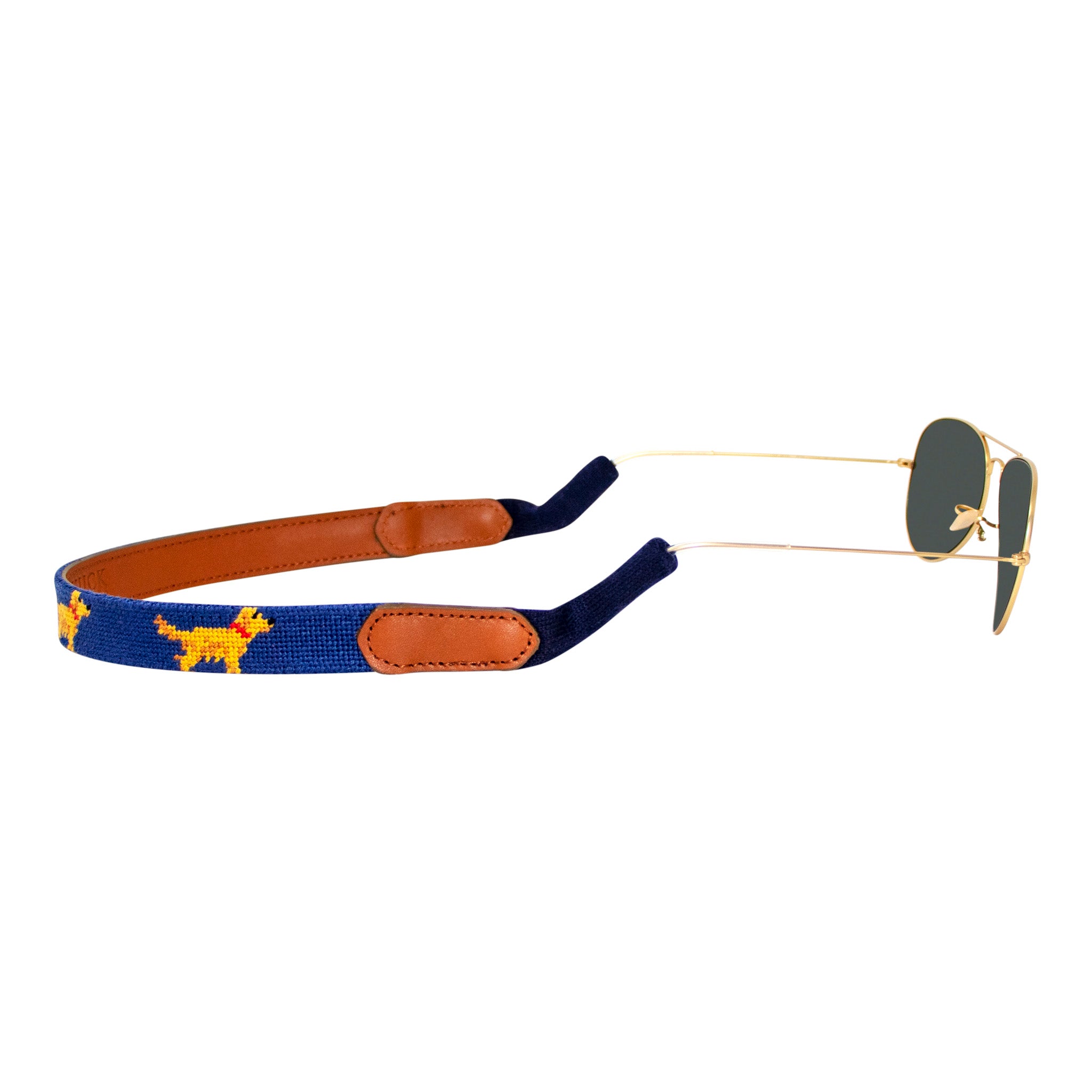 Golden retriever themed needlepoint sunglass strap showing a golden retriever design against a navy blue background with sturdy cotton covered silicone ear connectors and a soft leather backing