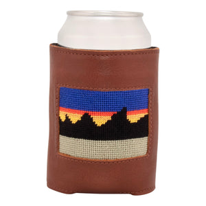 Front face of mountain range needlepoint can cooler showing hand-stitched needlepoint mountain range inspired by Montana. Soft leather body with interior neoprene lining. Great fit for a standard 12 ounce can.