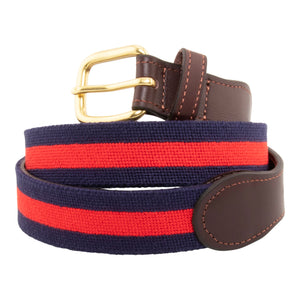Navy Stripe Needlepoint Belt with a dark navy blue background showing a red stripe 1/3 the width of the belt going down the center of the belt. Belt has a brass buckle and full grain leather backing and strap.