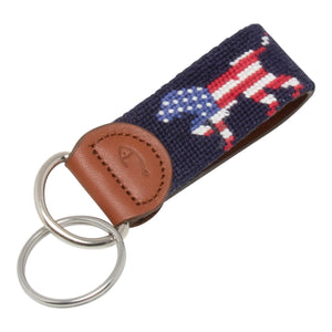 Hand-stitched Patriotic Dog needlepoint keychain showing an American Flag colored dog on both sides against a navy blue background and leather backing.  Stainless steel D-ring and keyring.