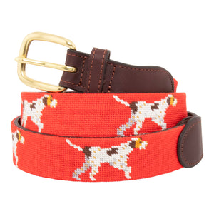 Pointer Dog Needlepoint Belt with a blaze orange background showing a repeating pattern of evenly spaced upland hunting dogs in a pointing stance. The belt has a brass buckle and full grain leather backing and strap.