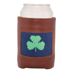 Front face of shamrock needlepoint can cooler showing hand-stitched needlepoint green shamrock against a dark navy blue background. Soft leather body with interior neoprene lining. Great fit for a standard 12 ounce can.