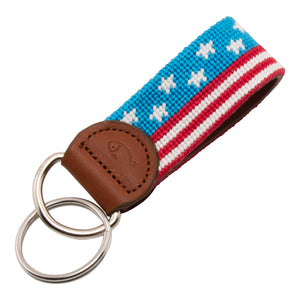 USA Flag Banner Needlepoint Keychain showing the American Flag in banner format wrapping around to both sides of the key fob.  Keychain has a leather backing and durable stainless steel D-Ring and keyring.
