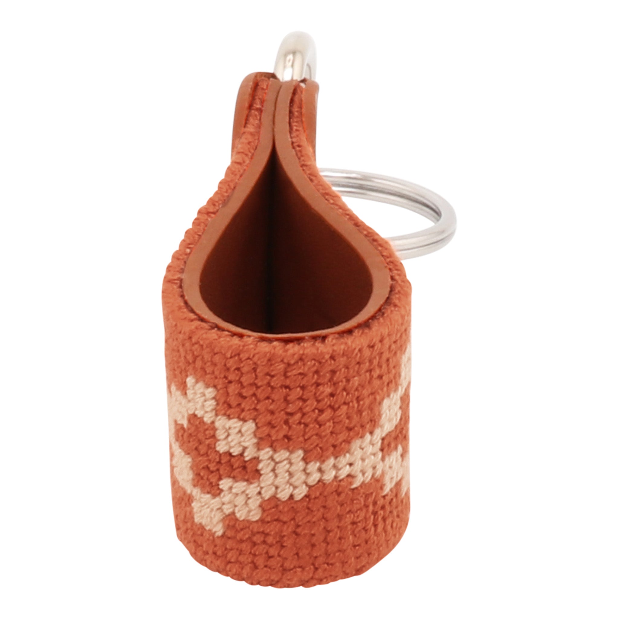 Hand-stitched Argentinian needlepoint key fob with terracotta canvas, cream geometric pattern, and fine-grain leather trim featuring stainless steel key rings.