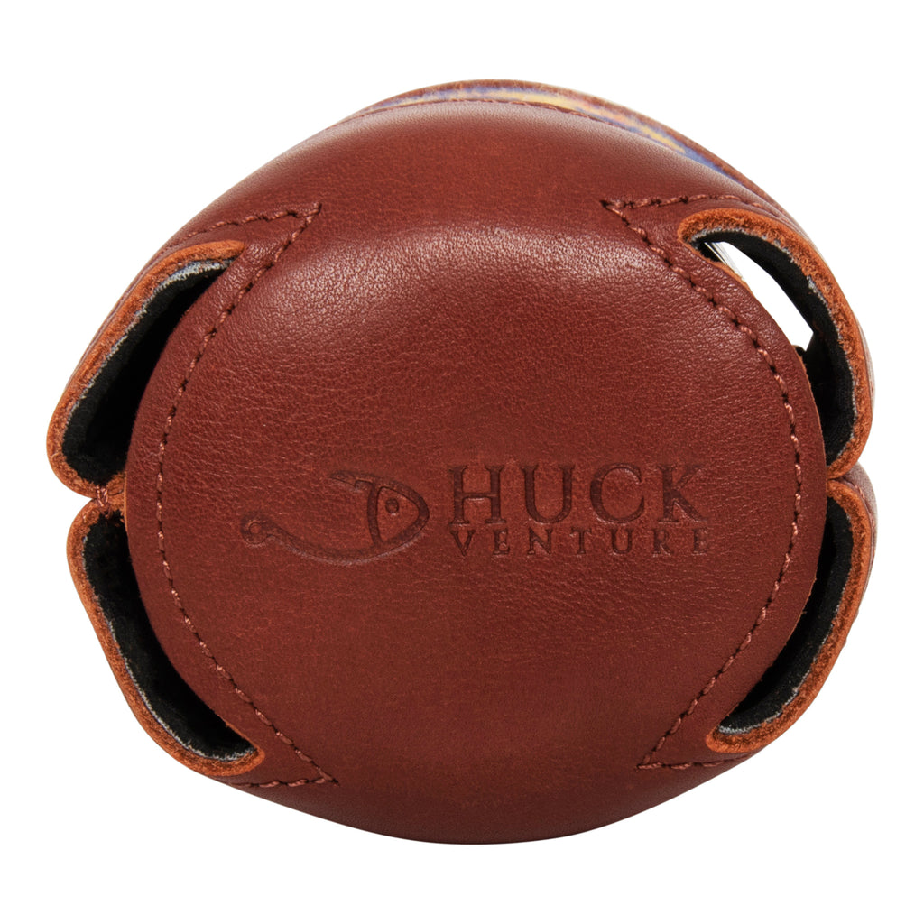 Bottom view of brown leather needlepoint can cooler featuring debossed Huck Venture logo with stitched detailing and cutout base design