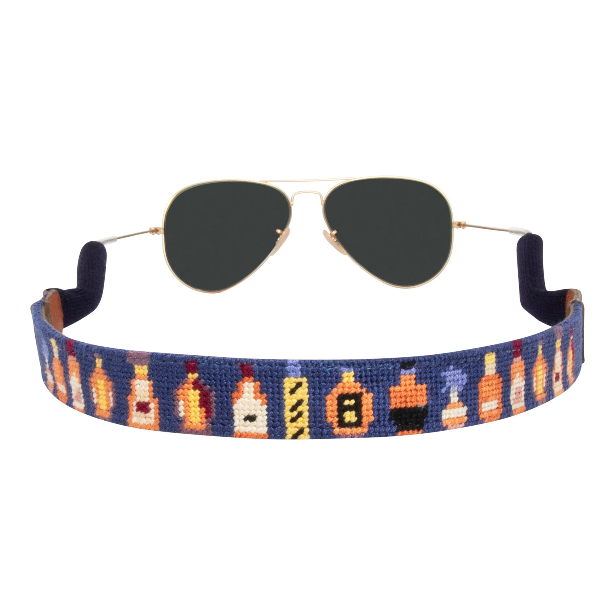 Back view bourbon bottle themed needlepoint sunglass strap showing popular bourbons against a navy blue background with sturdy cotton covered silicone ear connectors and a soft leather backing