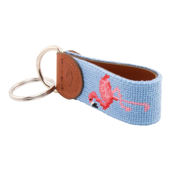 needlepoint keychain showing a pink flamingo on both sides against a light blue background, hand-stitched, leather backing, and stainless steel hardware