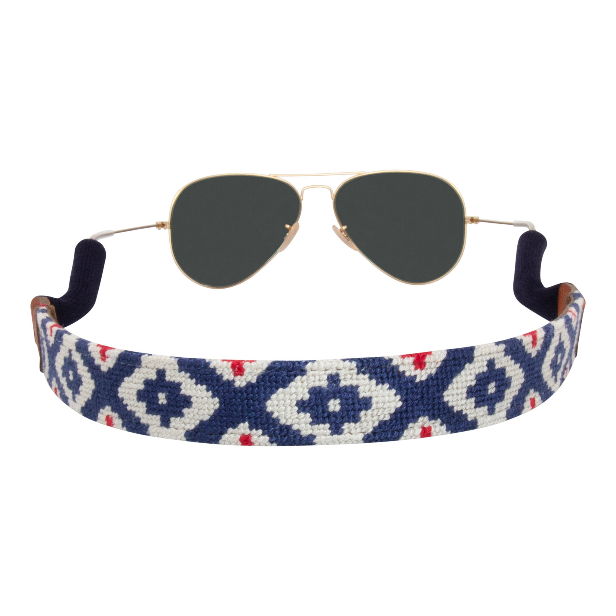 Side view gaucho needlepoint sunglass strap showing a red white and blue classic gaucho pattern with sturdy cotton covered silicone ear connectors and a soft leather backing