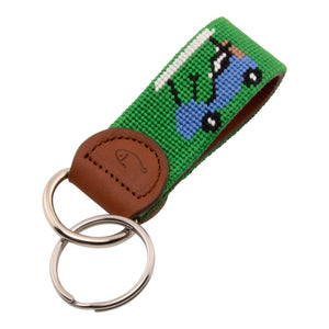 Hand-stitched golfing themed needlepoint keychain showing crossed golf clubs on both sides against a green background and leather backing.  Stainless steel D-ring and keyring.