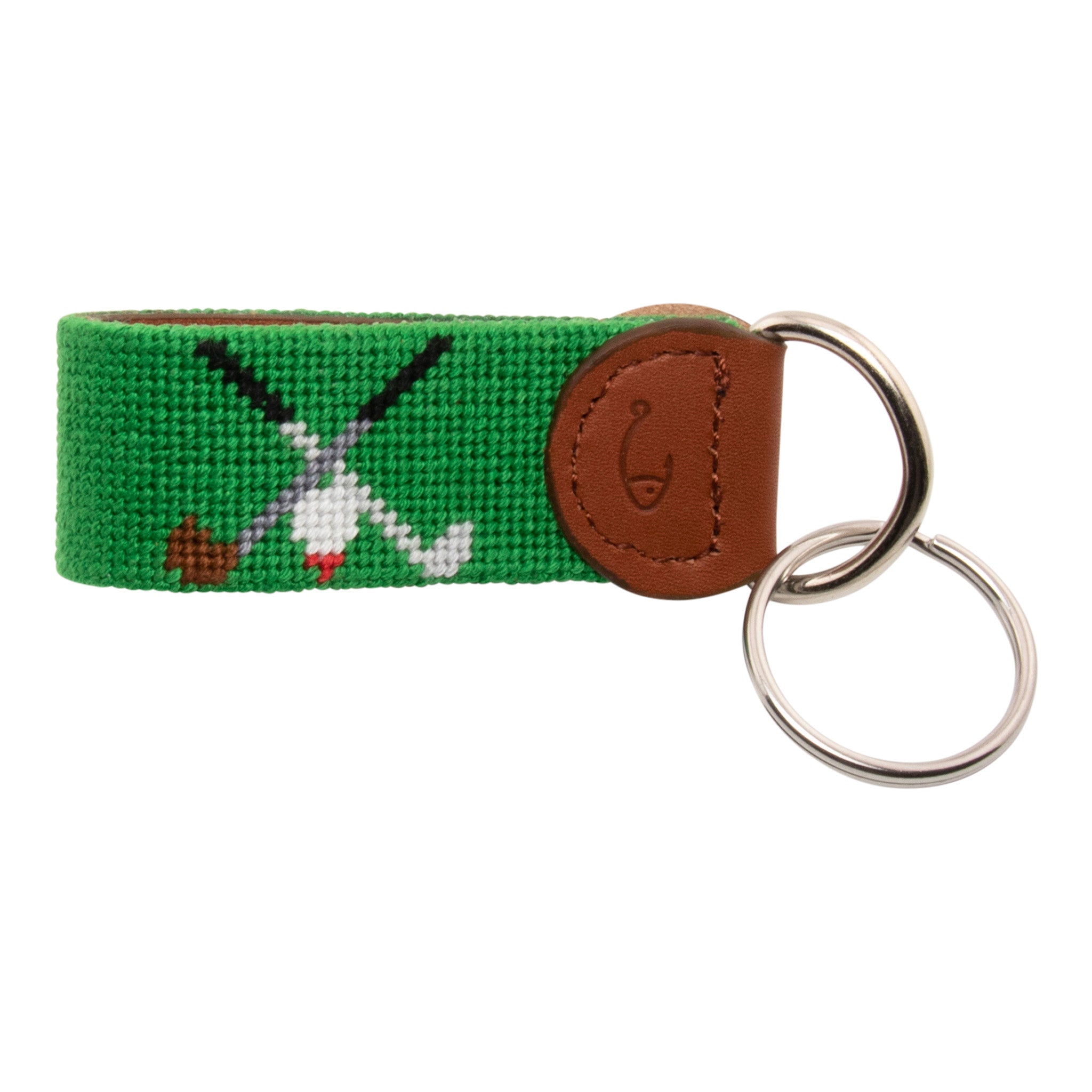 Hand-stitched golfing themed needlepoint keychain showing crossed golf clubs on both sides against a green background and leather backing.  Stainless steel D-ring and keyring.