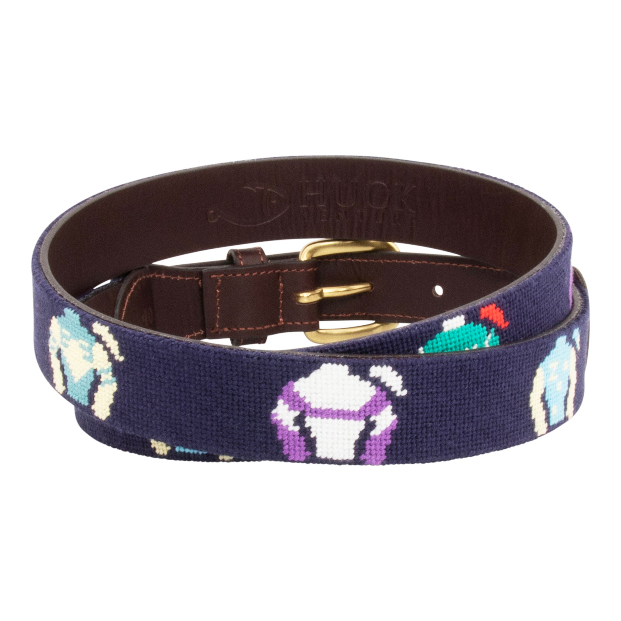 Jockey Silk Needlepoint Belt with navy blue background showing a repeating pattern of colorful racing jockey silks and cap. Belt has a brass buckle and full grain leather backing and strap.