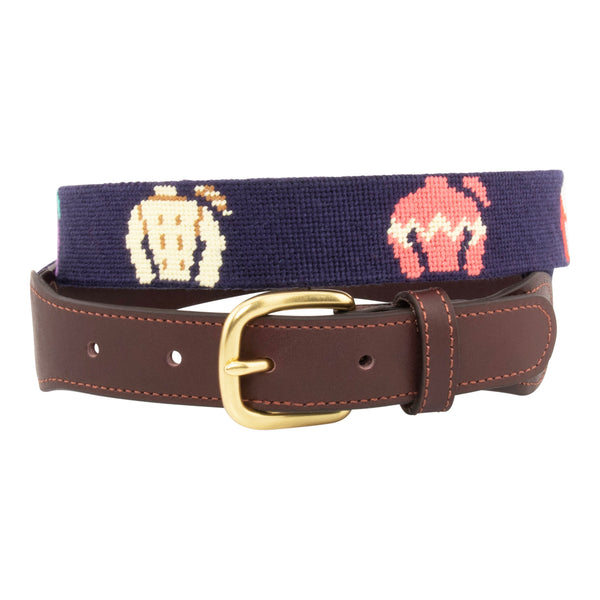 Jockey Silk Needlepoint Belt with navy blue background showing a repeating pattern of colorful racing jockey silks and cap. Belt has a brass buckle and full grain leather backing and strap.