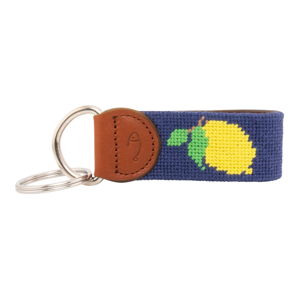 Hand-stitched lemon needlepoint keychain showing a Positano lemon on both sides against a navy blue background and leather backing.  Stainless steel D-ring and keyring.