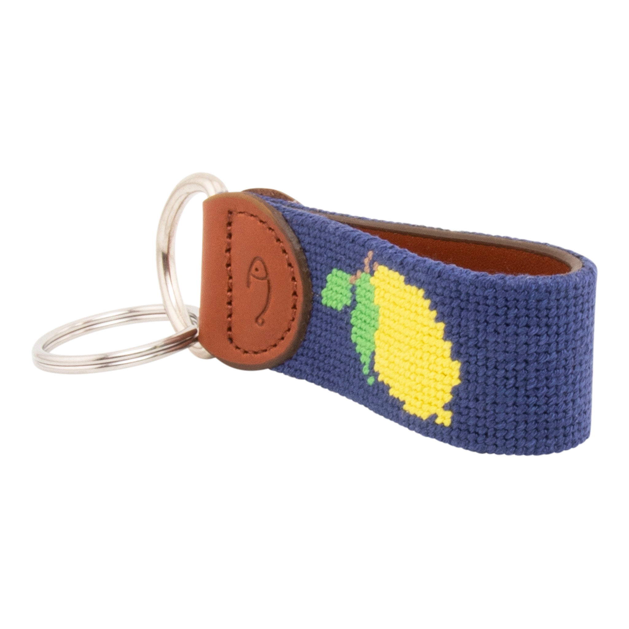 Hand-stitched lemon needlepoint keychain showing a Positano lemon on both sides against a navy blue background and leather backing.  Stainless steel D-ring and keyring.