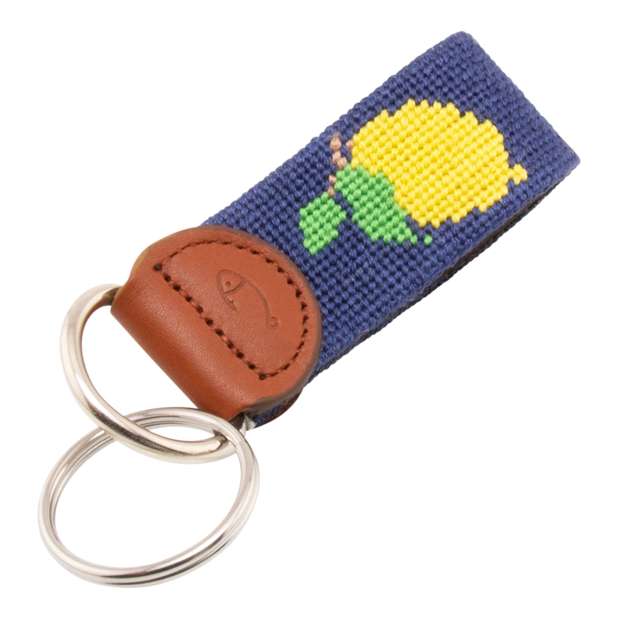 Hand-stitched lemon needlepoint keychain showing a Positano lemon on both sides against a navy blue background and leather backing.  Stainless steel D-ring and keyring.