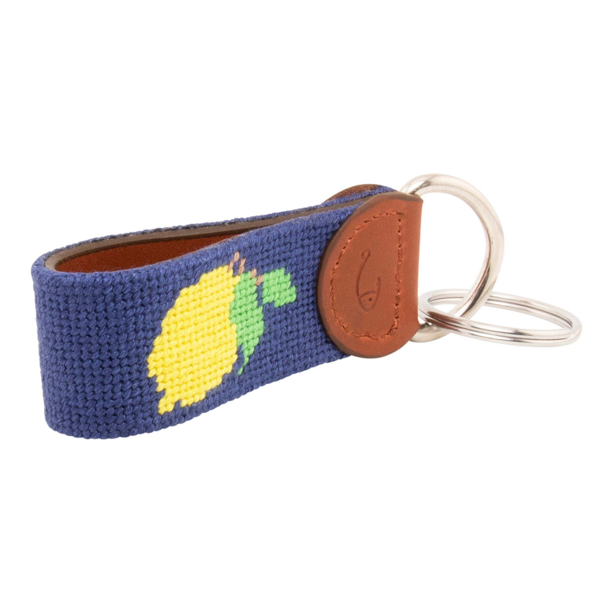 Hand-stitched lemon needlepoint keychain showing a Positano lemon on both sides against a navy blue background and leather backing.  Stainless steel D-ring and keyring.