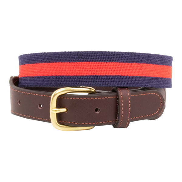 Navy Stripe Needlepoint Belt with a dark navy blue background showing a red stripe 1/3 the width of the belt going down the center of the belt. Belt has a brass buckle and full grain leather backing and strap.