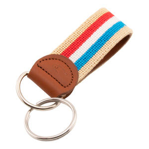 needlepoint keychain with blue white and red stripes on light tan background, design wraps around to both sides, hand-stitched, leather background, stainless steel key ring, same design on both sides