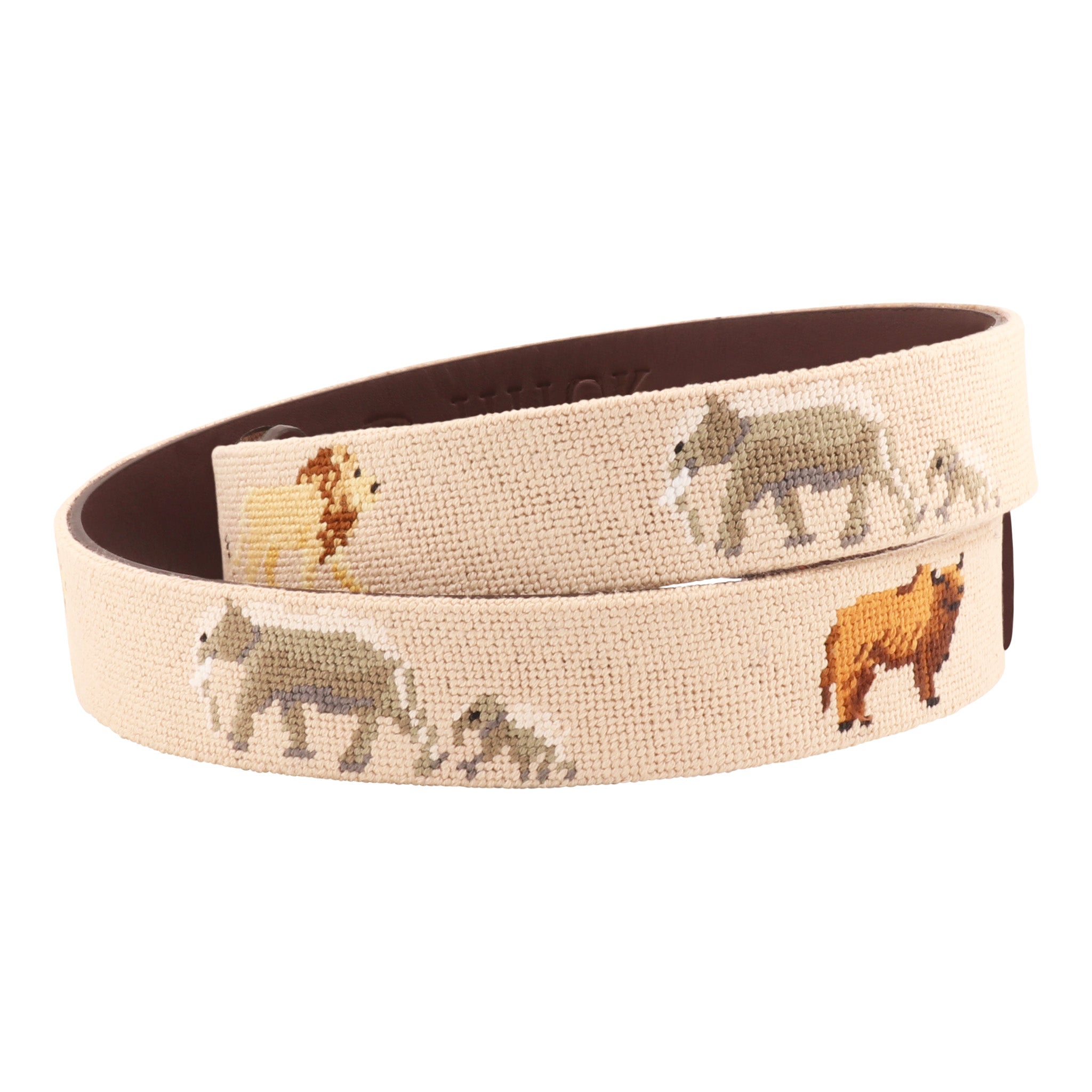 Close-up of safari needlepoint belt showcasing embroidered lion, elephant, and buffalo on tan canvas with leather backing