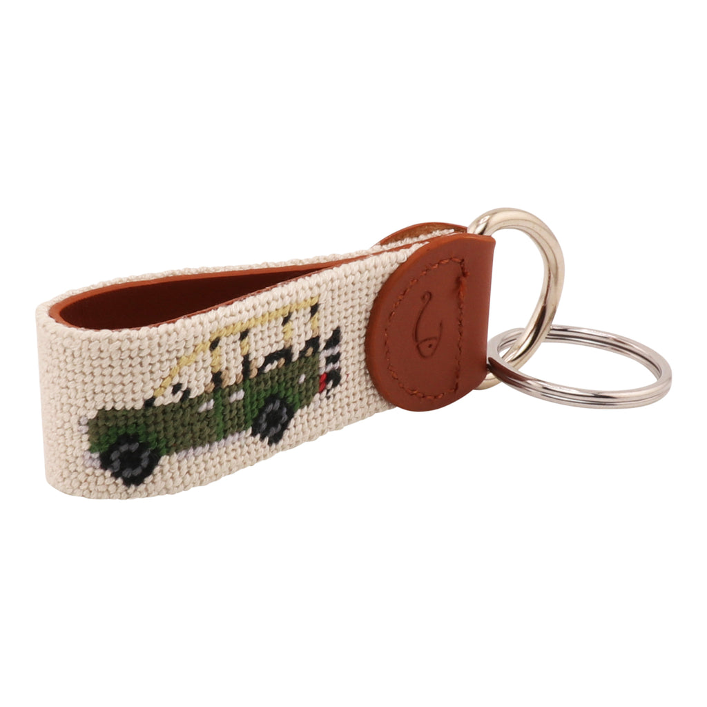 Hand-stitched Safari Needlepoint Key Fob with green safari vehicle design, full-grain leather backing, and stainless steel key ring by Huck Venture.