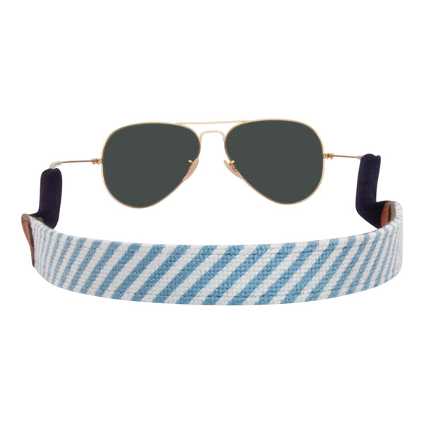 Back view seersucker needlepoint sunglass strap showing a blue and white seersucker classic pattern with sturdy cotton covered silicone ear connectors and a soft leather backing