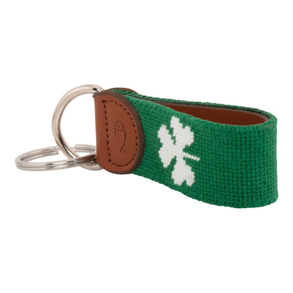 Hand-stitched shamrock needlepoint keychain showing a green shamrock on both sides against a navy blue background and leather backing.  Stainless steel D-ring and keyring.