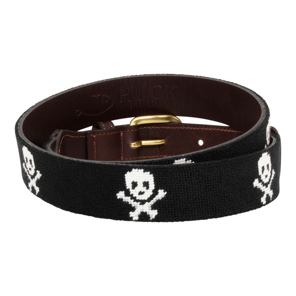 Jolly Roger Needlepoint Belt with black background showing a repeating pattern of evenly spaced white skull and crossbones pattern. Belt has a brass buckle and full grain leather backing and strap.