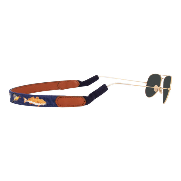 Side view southern sportsman themed needlepoint sunglass strap showing shotgun dove pointer dog fish patterns against a navy blue background with sturdy cotton covered silicone ear connectors and a soft leather backing